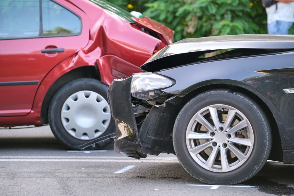 Vehicles damaged in a heavy car accident after a collision on a city street crash site. Road safety and insurance concept.