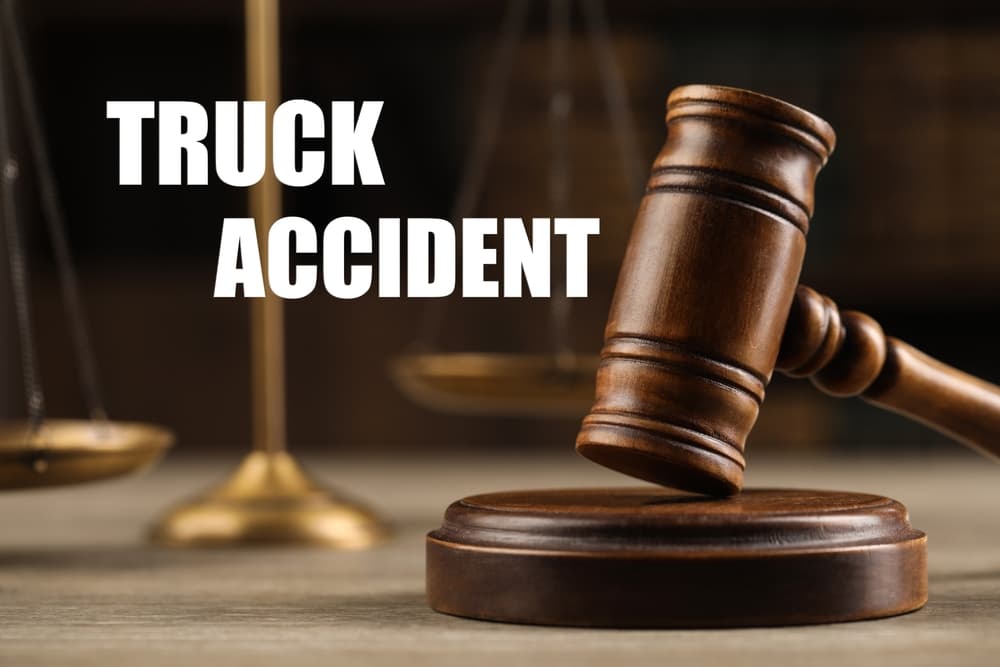 Wooden judge's gavel and scales of justice on a table, symbolizing truck accident law and legal proceedings.
