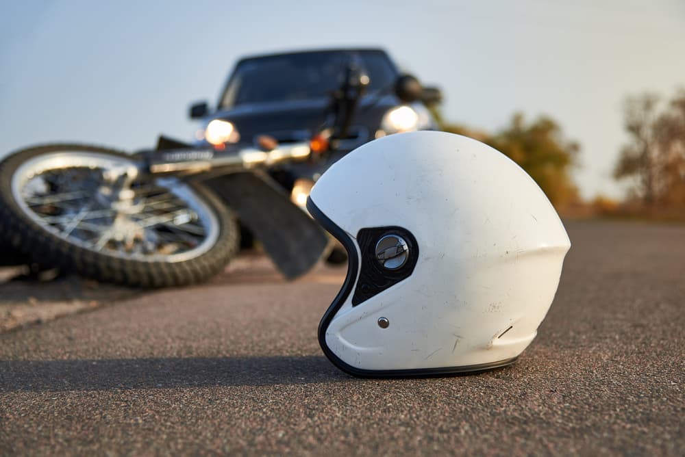 Photo of car, helmet and motorcycle on road, the concept of road accidents.