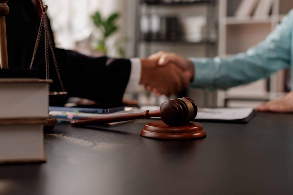 Lawyer and client shaking hands in an office after signing a legal agreement. Lawyer and client shaking hands in an office after signing a legal agreement.