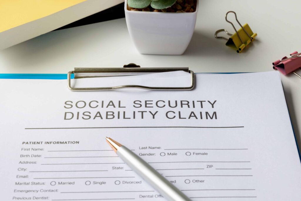 Social Security Disability claim form with pen on clipboard, ready for application. Social Security Disability claim form with pen on clipboard, ready for application.
