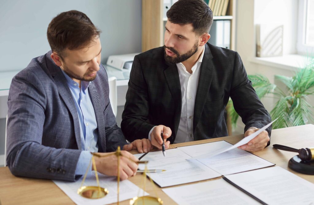 Lawyer discussing legal documents with a client in an office setting.