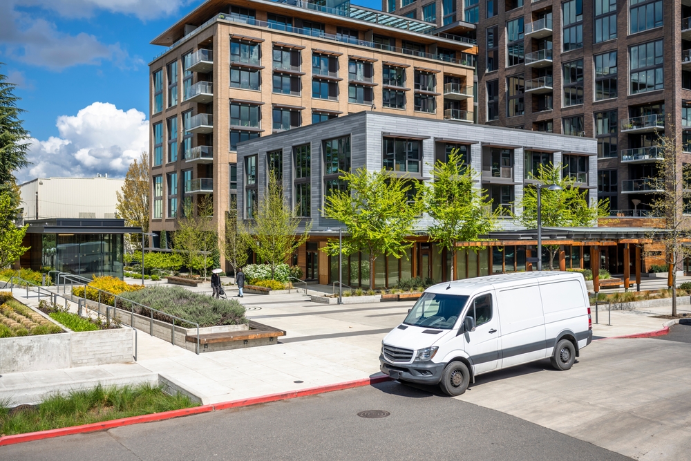 Delivery van without major shipper branding outside office or apartment building