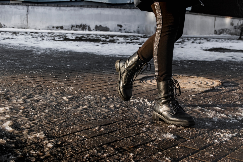 Woman walking along unmaintained and icy sidewalk